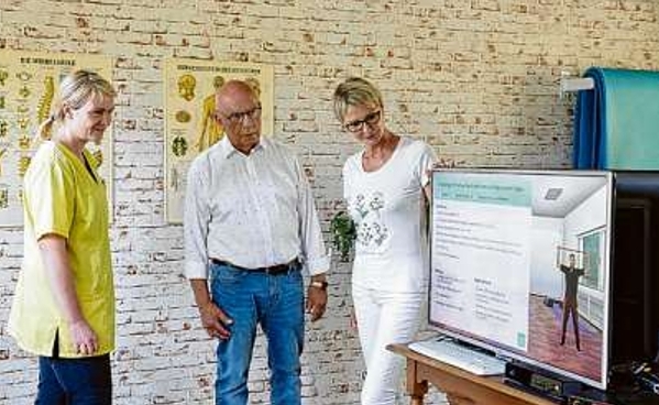 Im Therapiezentrum Cementa Feller (r.) in Senftenberg ist das internetbasierte Training vor einem großen Bildschirm möglich. Prof. Fritjof Reinhardt (M.) möchte erreichen, dass die App auch im häuslichen Umfeld anwendbar wird.