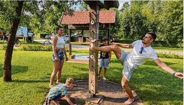 Haben viel Spaß im Burger Barfußpark: Norbert Mielenz und Franziska Schulz mit ihren Jungs aus der Pfalz. Vater Norbert hangelt geschickt einen Ring auf einen Haken.
