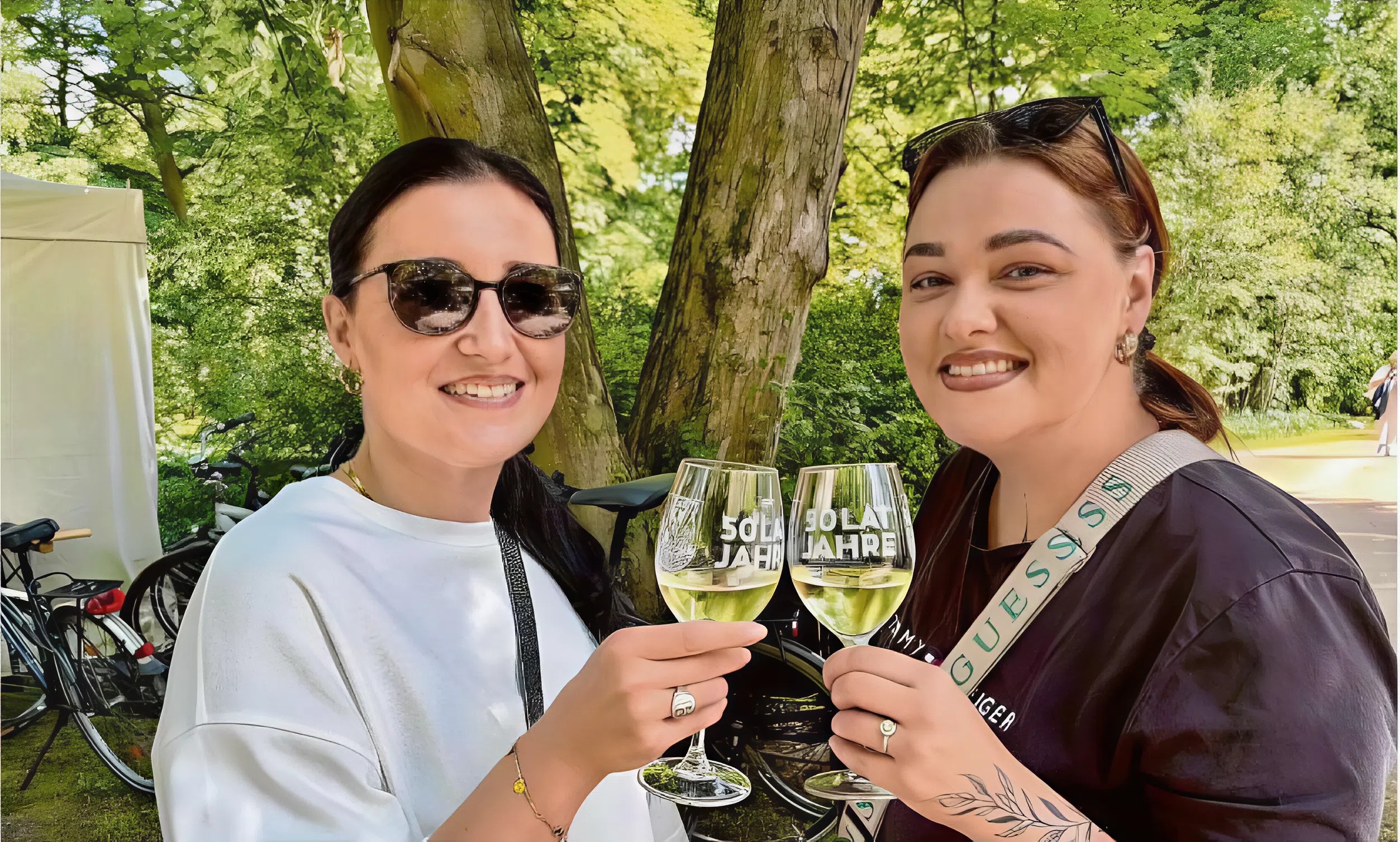 Gwendy Fischer (l.) und Gina Gorenz stoßen mit einem Glas Kerner vom Weingut Klaus Böhme an. Sie sind begeistert vom Ambiente des Weinfestes im Branitzer Parkin Cottbus.
