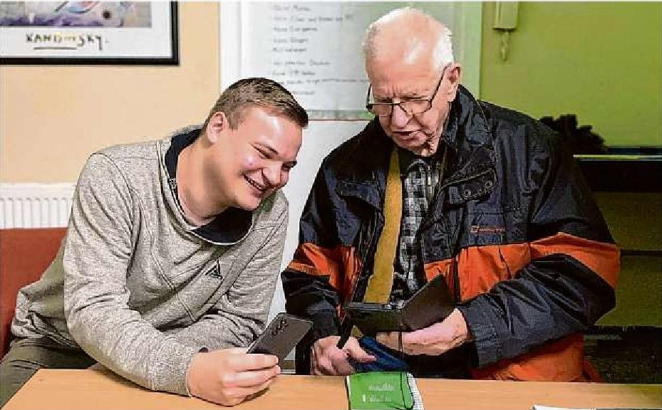 David Grescho (l.) hilft Peter Domschke aus Cottbus mit seinem Smartphone. Die großen Fragen: Wie wird die Stummschaltung aufgehoben, und warum kommen keine Anrufe durch?