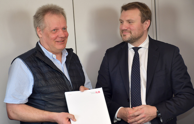 Wirtschaftsminister Daniel Keller (rechts) übergibt den 1000. Zuwendungsbescheid des Förderprogramms BIG-Digital an Geschäftsführer Hagen Koch (links) von der TSK Anlagenbau GmbH.