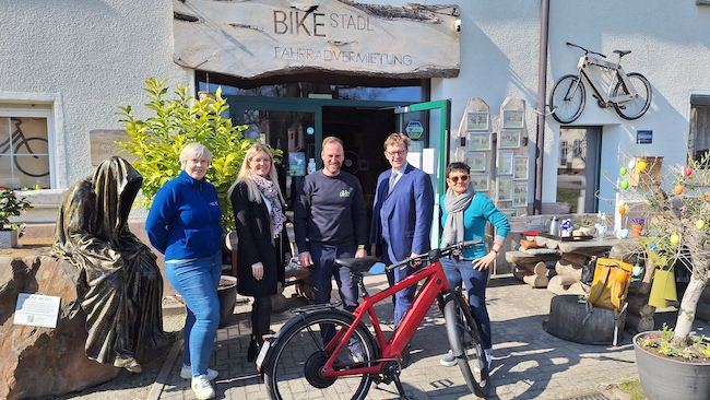auf auf's Rad heißt es im Bike Stadl am Dorfanger von Großkoschen schon seit den ersten warmen Sonnenstrahlen im Februar. Alexander Hartmann (3.v.r.) hat für den Besuch des Bürgermeisters (2.v.r.) schon mal ein feuerrotes Mountainbike in Stellung gebracht.