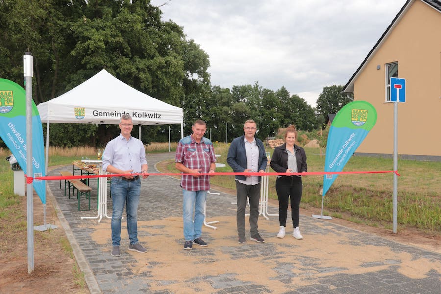 Das Band schneiden durch (vl.): Heiner Stephan (Niederlassungsleiter Cottbus Voigt Ingenieure), Wolfram Ludwig (Geschäftsführer Argus Straßenbau), Karsten Schreiber (Bürgermeister Gemeine Kolkwitz) und Sarah Mrosko (Ortsbeirat Milkersdorf).