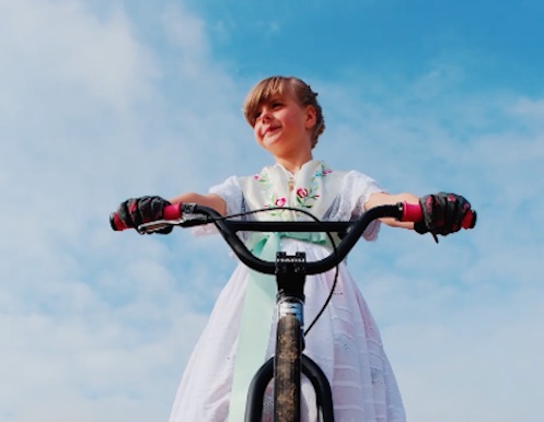 Amelie Didoff in Tracht auf Ihrem BMX Rad, das vollständige Foto ist im Filmclip sichtbar