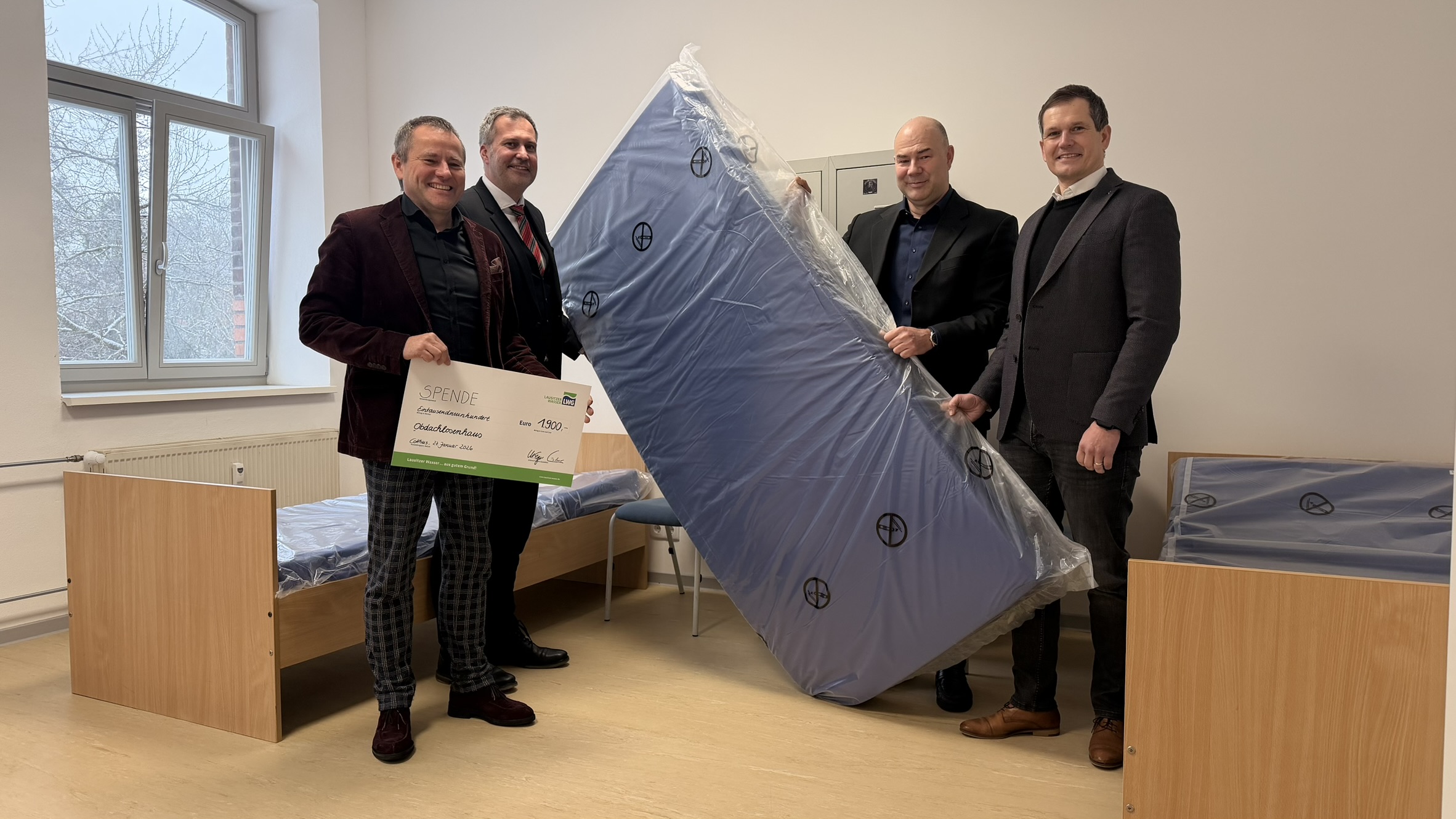 Marten Eger (Geschäftsführer LWG), Oberbürgermeister und Aufsichtsratsvorsitzender der LWG, Tobias Schick, René Schultchen (Vorstandsvorsitzender DRK-Kreisverband Cottbus-Spree-Neiße-West e.V.) und Sebastian Lindner (Geschäftsführer LWG) übergeben Spendenscheck für Matratzen und Wä- schetrockner.