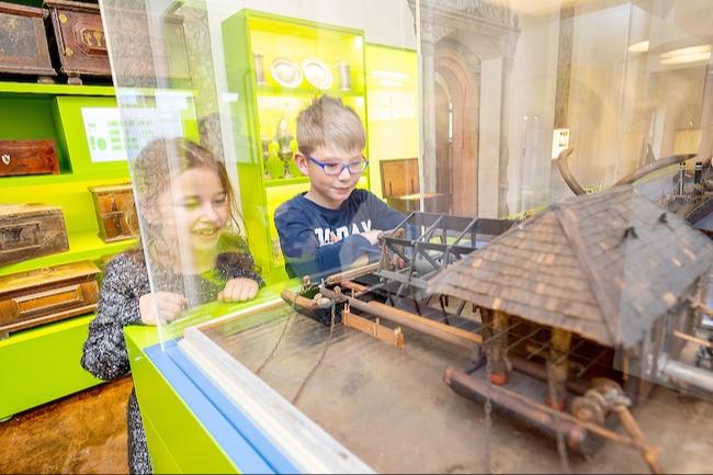Neugierig blicken Kinder in eine Glasvitrine im Museum Mühlberg 1547 – auf Spurensuche nach dem Geheimnis der doppelten Stadt. Beim Familiensonntag am 10. Mai entdecken sie spielerisch, warum Mühlberg einst in Alt- und Neustadt geteilt war, lernen spannende Berufe der Elbeschifffahrt kennen und tauchen mit kleinen Mitmachaktionen in die Geschichte ein.