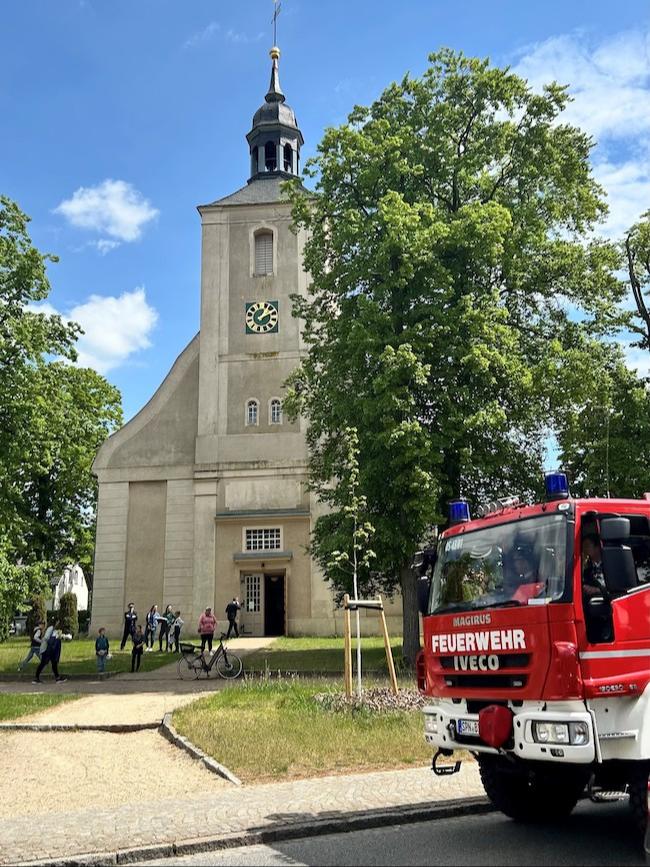 Ein Feuerwehrauto steht vor der Burger Kirche: Bereits 2025 hat es den ersten Feuerwehrgottesdienst gegeben, organisiert vom Feuerwehrverein, der 2024 gegründet wurde.