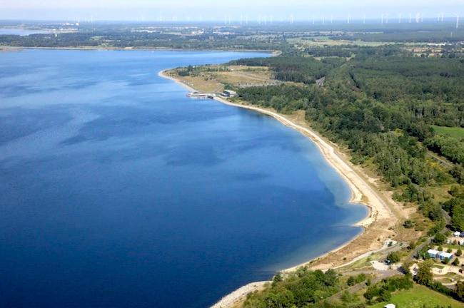 Nordostböschung des Sedlitzer Sees mit Seestrand Lieske und Sanierungsstützpunkt im Hintergrund