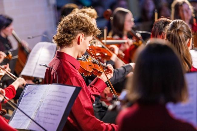 Die Musikerinnen und Musiker des Sinfonieorchesters der Kreismusik- und Kunstschule Gebrüder Graun musizieren während eines Konzertes mit großer Konzentration und Ausdruckskraft.