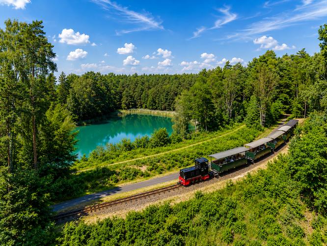 Smaragdgrün, dunkelgrün oder rostbraun – die ungewöhnlichen Farben der Seen sind kein Zufall. Sie erzählen die Entstehungsgeschichte einer Landschaft, die während der Eiszeit geformt und später durch den Bergbau weiter geprägt wurde.