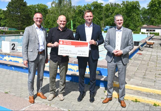 Landrat Marcel Schmidt (2.v.r.), Sparkassen-Vorstandsvorsitzender Frank Prescher (r.) und Vorstandsmitglied Thomas Jentzsch (l.) übergaben gemeinsam mit Bürgermeister Karsten Eule-Prütz einen Spendenscheck in Höhe von 10.000 Euro zur Unterstützung des Herzberger Freibades.