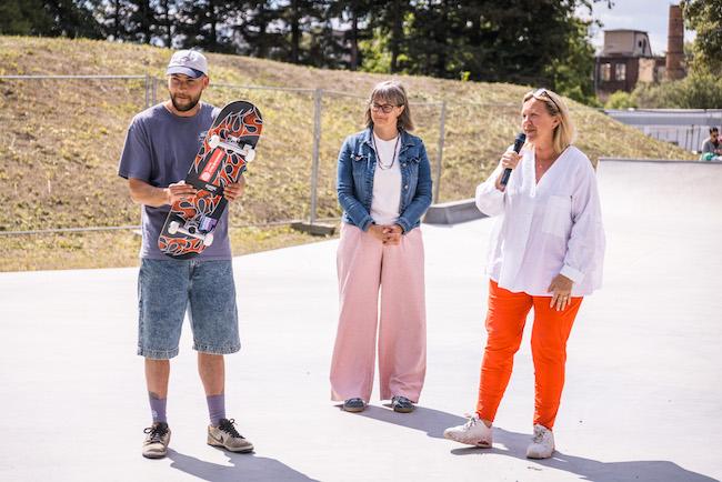 Offizieller Banddurchschnitt (Bild 2) und Übergabe eines Skateboards ( Bild 1) durch die Bürgermeisterin der Stadt Forst (Lausitz, Simone Taubenek, im Beisein der Geschäftsführerin von 360 ° Landschaftsarchitekten, Anne-Katrin Steiniger, gemeinsam mit Vertretern aus Verwaltung, Skatern und dem Kinder- und Jugendbeirat.