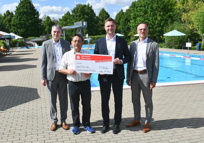 Tröbitz: Landrat Marcel Schmidt (2.v.r.), Sparkassen-Vorstandsvorsitzender Frank Prescher (l.) und Vorstandsmitglied Thomas Jentzsch (r.) übergaben gemeinsam mit Bürgermeister Holger Gantke einen Spendenscheck in Höhe von 10.000 Euro zur Unterstützung des Freibades Tröbitz.