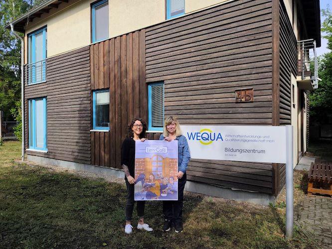 Dr. Cindy Hader, Projektleiterin Grundbildungszentrum (li.) und Katrin Müller, Bildungskoordinatorin bei der WEQUA, vor dem künftigen neuen Lerncafé in Lauchhammer.