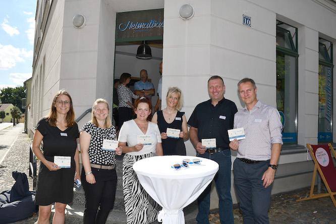 Mit der offiziellen Eröffnung der Heimatbasis in der Kirchstraße 10 in Herzberg ist eine neue Anlaufstelle für Bundeswehrfamilien, Rückkehrer und Zuziehende an den Start gegangen. Gemeinsam gaben die Projektpartner den Auftakt für das Willkommensangebot in Elbe-Elster v.l.n.r.: Melanie Mietsch (Leiterin Heimatbasis), Ariane Kölling (Leiterin des Kreisentwicklungsamtes LKEE), Julia Procopius (Projektkoordinatorin Comeback Elbe-Elster), Stephanie Kuntze (stellvertretende Bürgermeisterin Stadt Herzberg), Christoph Schulze (Stellvertretender Bürgermeister Stadt Schönewalde) und Sven Guntermann (Vorsitzender des Vereins Generationen gehen gemeinsam G3 e. V.).