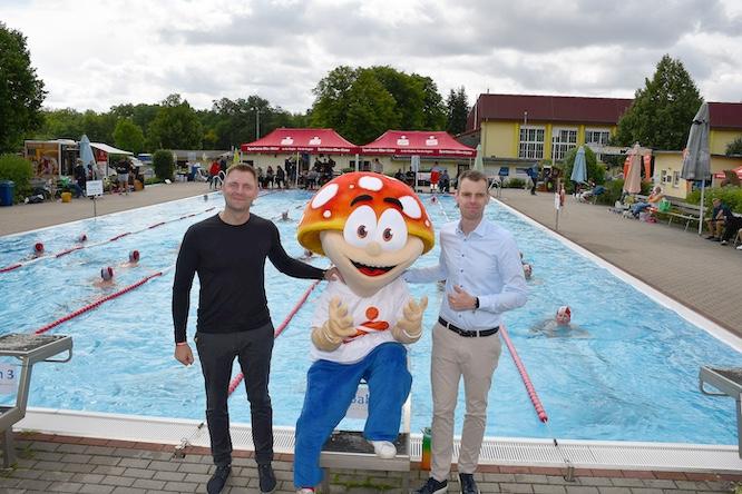  Gemeinsam für Bewegung, Gemeinschaft und den Erhalt des Freibades: Landrat Marcel Schmidt (l.), Sparkassen-Glückspilz Winni und Marcus Vandreier von der Sparkasse Elbe-Elster am Beckenrand des Tröbitzer Erlebnisbades.