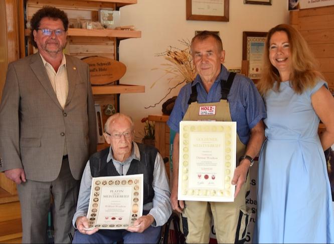 Tischlermeister Wilfried Woidtow (2.v.l.) wurde mit dem Platin-Meisterbrief der Handwerkskammer Cottbus für seine Lebensleistungen und 70-jähriges Meisterjubiläum geehrt. Sein Sohn Tischlermeister Dietmar Woidtow (3.v.l.) erhielt als Auszeichnung den Goldenen Meisterbrief für sein 50-jähriges Meisterjubiläum. Die Anerkennung und Gratulationen überbrachten Guntram Bialas, Vorstandsmitglied der Handwerkskammer Cottbus und Sylke Radke, Hauptgeschäftsführerin der Handwerkskammer Cottbus.