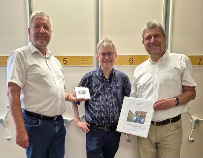 Ortschronist Gerald Svarovky übergibt Stadt- archivar Dr. Jan Gülzau und Oberbürger- meister Holm Große (v.l.n.r.) die Foto- dokumentation über die Stadt Bischofswerda.