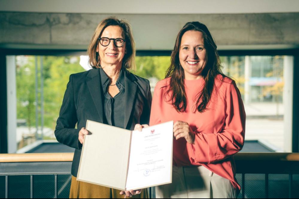 Die brandenburgische Wissenschaftsministerin Manja Schüle überreicht die Ernennungsurkunde an Gesine Grande.