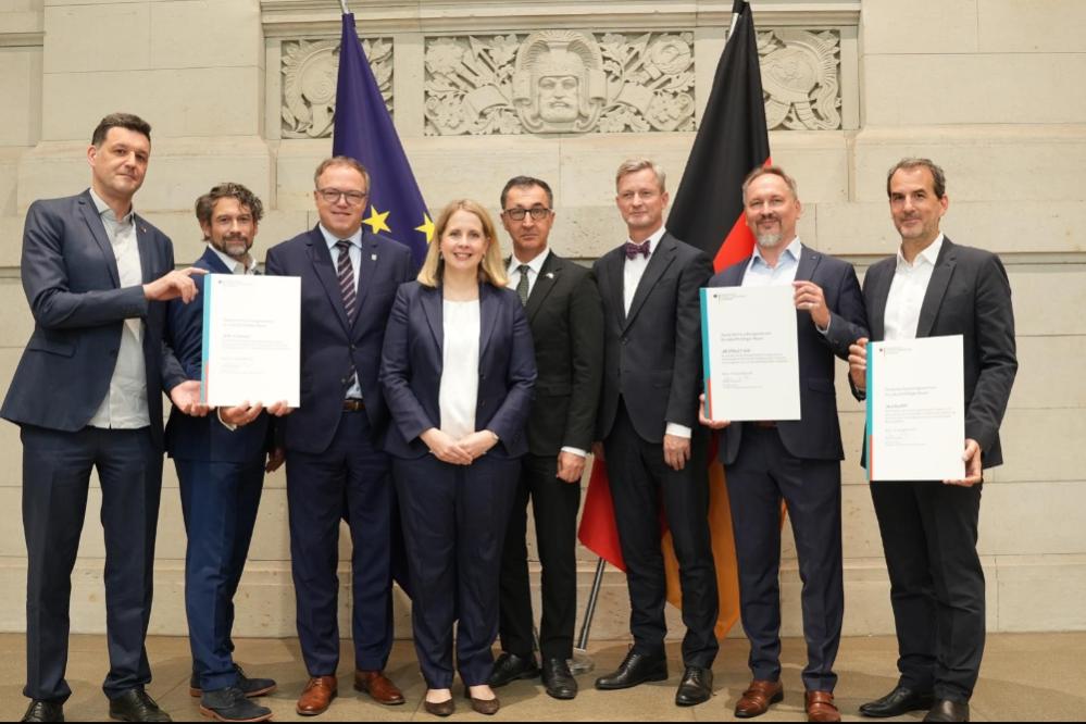 Am Freitag, 25. September 2026, überreichte Bundesbauministerin Verena Hu- bertz den drei Gründungsmitgliedern des Deutschen Forschungszentrums für zukunfts- fähiges Bauen (DFZ Bau) in Berlin jeweils eine Millionen Euro Fördermittel.