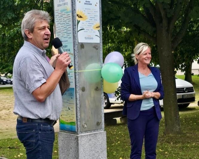 Oberbürgermeister Holm Große und Amtsleiterin, Sybille Müller, bei der Begrüßung der Neugeborenen im Salvetepark – gerade dabei die neue Namenstafel zu enthüllen.