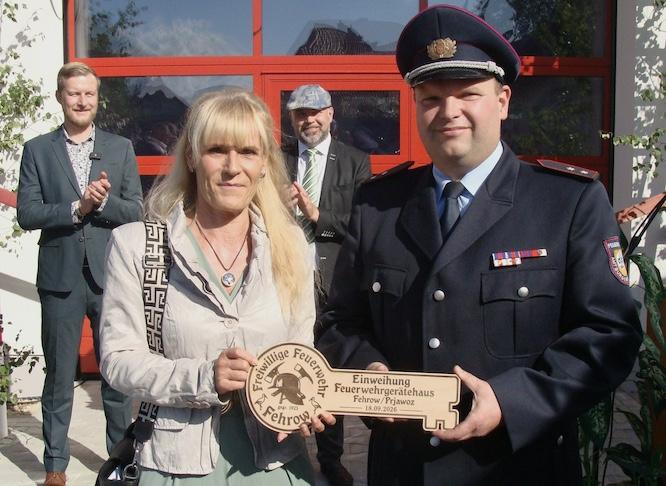 Bürgermeisterin Ira Frackmann übergibt den symbolischen Schlüssel für das neue Feuerwehrgerätehaus an Ortswehrführer Maik Eckert. Im Hintergrund Landrat Martin Heusler (l.) und Amtsdirektor Tobias Hentschel.